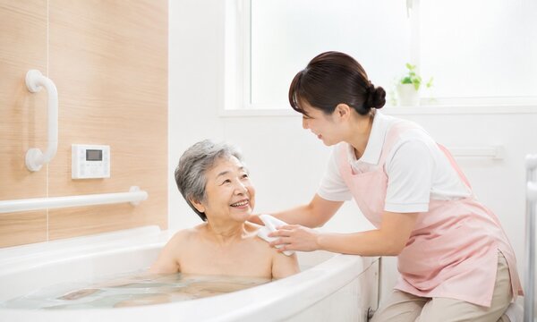 介護士が高齢女性の入浴をサポートする介護風景　安心できる入浴介助と生活支援