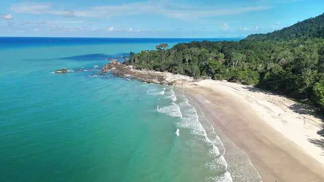 Aerial drone view of a hidden tropical beach with turquoise ocean, pristine sandy shoreline, lush rainforest and peaceful coastal paradise landscape
