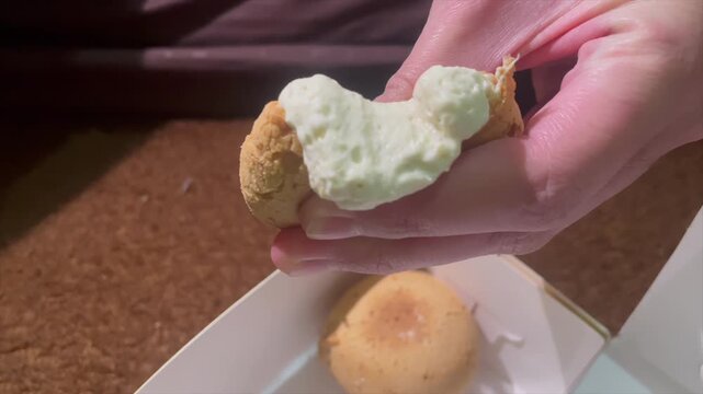 Hand holding creamy durian filled cream puff