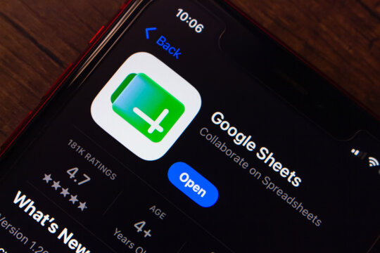 Mexico City, MEXICO - Jul 7 2026 : Close-up of a smartphone showing the Google Sheets app listing on the Apple App Store, on a dark wooden surface.