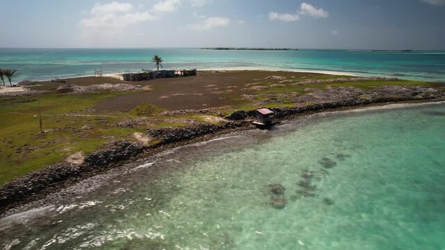 Unique marine heritage with Extensive Queen Conch shell mounds, a rustic fisherman&rsquo;s shack along the shoreline, shallow crystal-clear turquoise waters, and a pristine Caribbean coastal landscape.