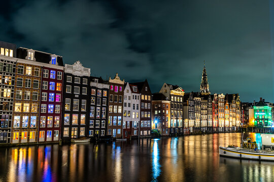 Amsterdam city at night. Old water canal houses in Netherlands. House Boat