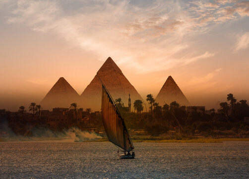 Beautiful Nile scenery with traditional Felluca sailing boat in the Nile on the way to Giza pyramids at night  - Cairo, Egypt