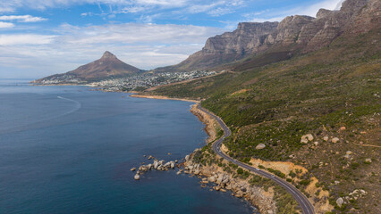 Scenic winding coastal road south of Camps Bay, South Africa, beneath a clear blue sky. Lion's Head and Camps Bay form a spectacular backdrop to one of Cape Town's most iconic coastal drives.