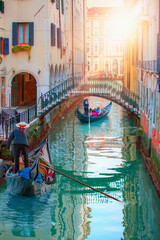 Venetian gondolier punting gondola through green canal waters of Venice, Italy © muratart