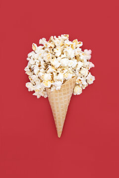 Bizarre summer popcorn ice cream cornet fun design on red background. Fun decorative food art holiday symbol for logo, greeting card.
