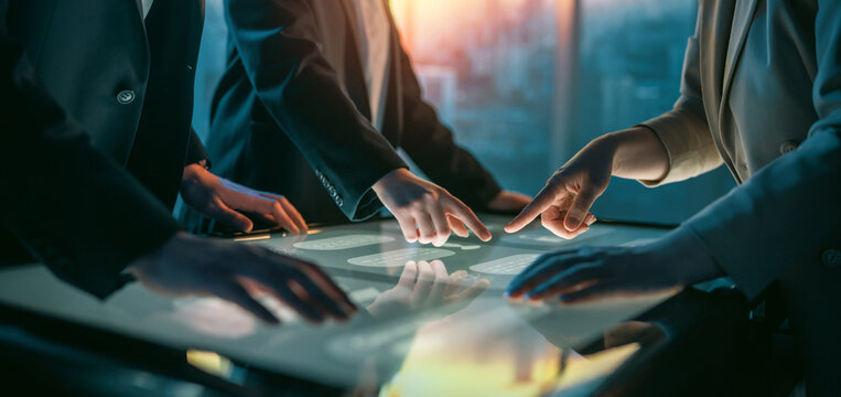 Business Team Collaborating on Interactive Touchscreen Table