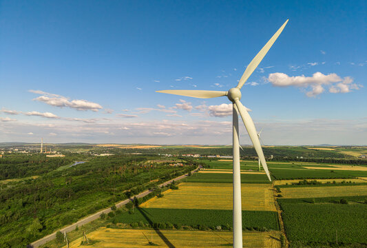 Wind turbine standing in green agricultural field, renewable energy production and sustainable industrial power concept