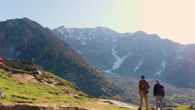 Hikers trekking in mountains. Travelers exploring nature at Kareri Lake, Kangra, Himachal Pradesh.