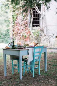 Laid garden table with candles next to a cottage