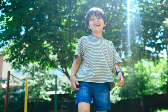 A smiling boy enjoys a summer walk in the sunny park