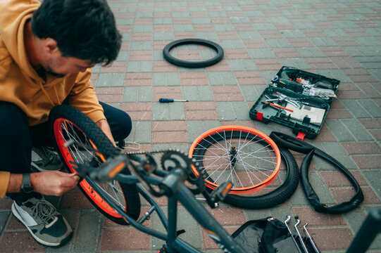 Dad repairing a bicycle wheel with tools outdoors