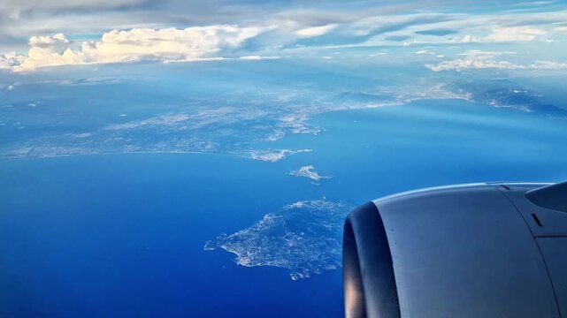 The islands of Procida and Ischia seen against the backdrop of the blue sky by an airplane passenger through the window