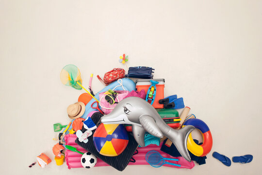 Colorful vacation luggage and beach items arranged in studio