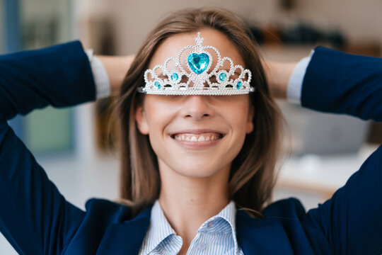 Ambitious young woman wearing crown as an award for her achievments