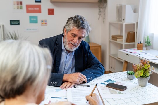 Confident business leader consulting with colleague in modern office