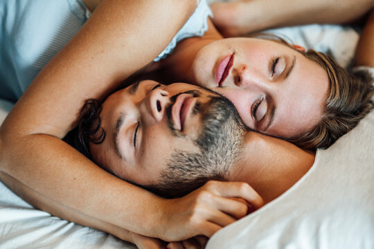 Young couple sleeping together at home