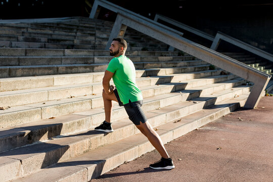 Sportive man during workout, stretching on steps