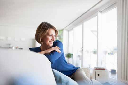 Smiling woman at home sitting on couch