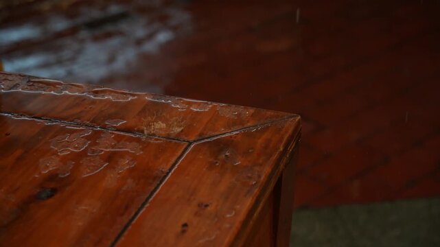 Raindrops falling on a wooden table