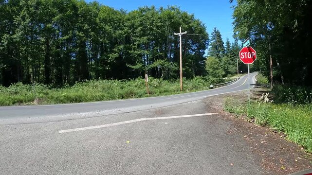 4K smooth action camera driving  footage from a hood mounted driver's POV along a scenic countryside road in Oregon, USA with forest, rural homes, fields and Pacific Northwest scenery