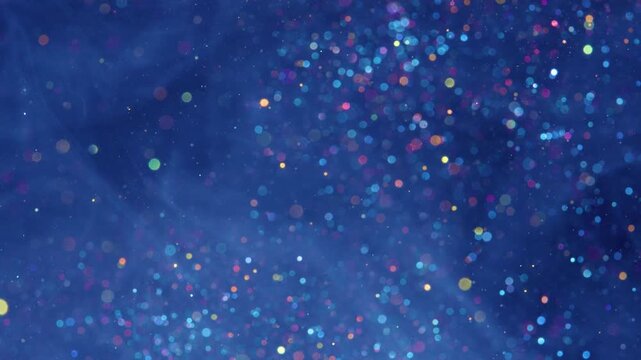 Shimmering abstract scene with dense multicolor outofocus light orbs over deep navy background, shifting from larger sparse highlights into finer glitterlike points, creating rich color contrast and
