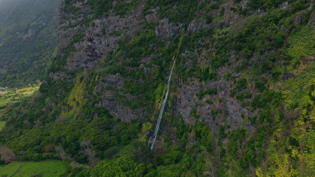 Mountain Waterfall Near The Village Of Faj&atilde; Grande On Flores Island In The Azores, Portugal. Aerial Pullback Shot