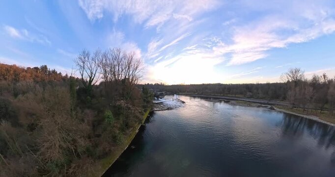 Stunning aerial 360 panoramic view capturing the serene landscape of Capriate San Gervasio, Italy, with a winding river and trees during a beautiful sunset.