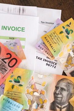 colourful Australian banknotes scattered on tax invoices EOFY concept
