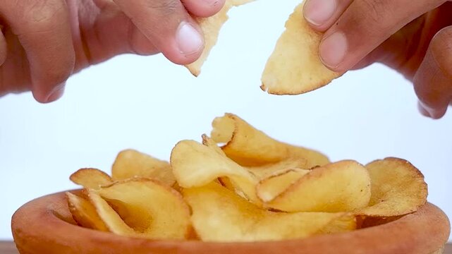 video of hand movements breaking cassava chips isolated on a white background