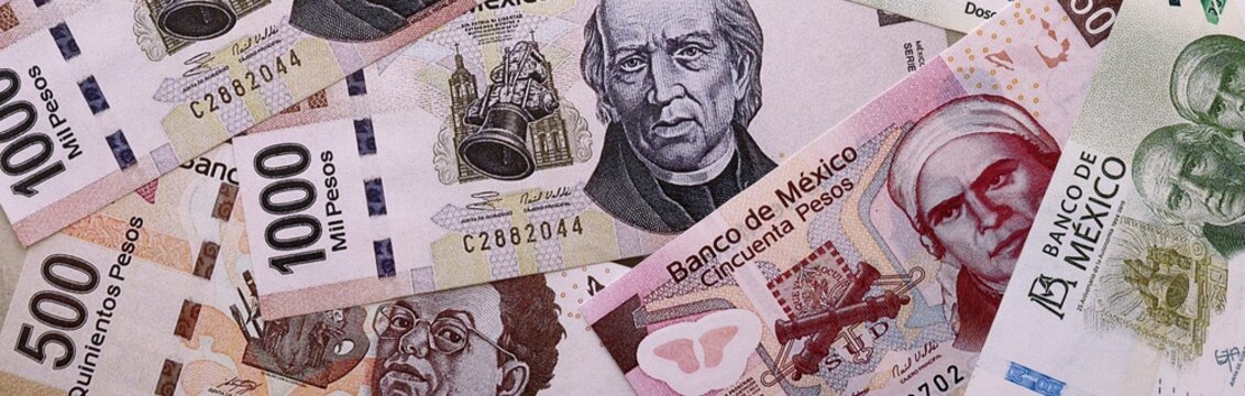 Mexican peso money bills pile on table. Mexico banknotes of MXN currency close up.