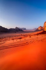 Fototapete Rot Vertical photo of sunrise on red sand dunes with vast landscape of Wadi Rum desert, Jordan.  © Tomasz