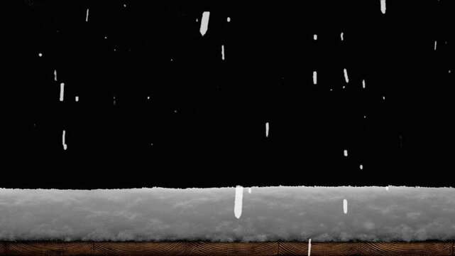 Snow falls on a wooden floor with a pile of snow