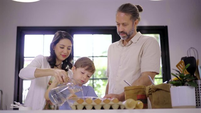 Interracial family cooking together in modern home kitchen