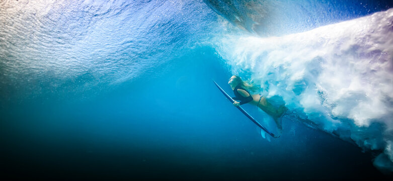 Dramatic low angle shot of powerful ocean wave cresting with white foam against deep blue water