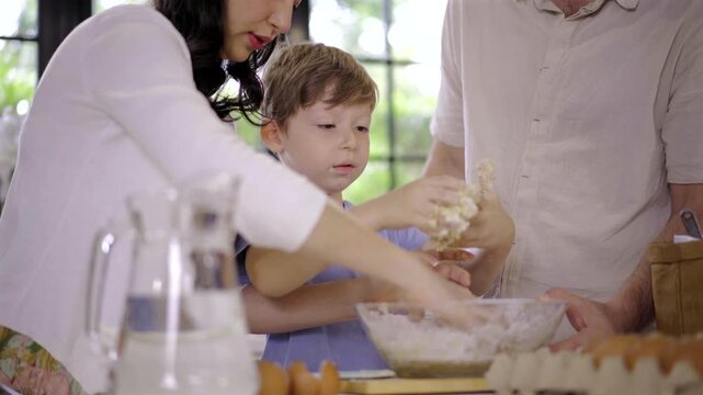 Caucasian family parent and son kneading dough for pizza or cookies