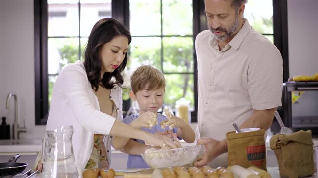 Caucasian family parent and son kneading dough for pizza or cookies