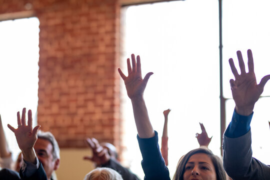 Hands raised in group meeting.