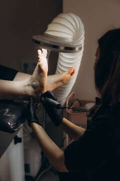 Pedicurist performing professional foot care treatment on client