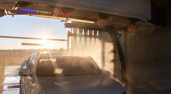Surface protectant cycle running while vehicle is in automatic car wash at sunset