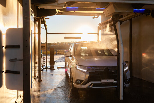 wash cycle running while vehicle is in automatic car wash at sunset