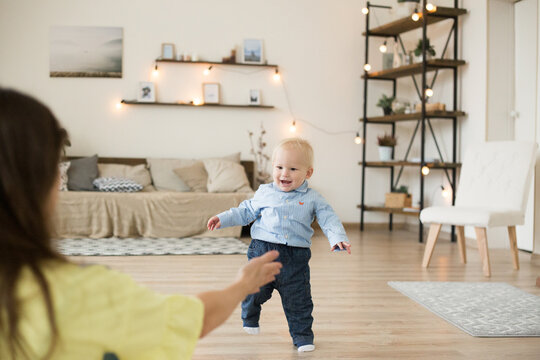 Toddler taking first steps toward mother at home