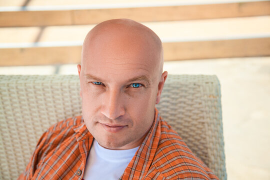 Bald Man with Blue Eyes in an Orange Plaid Shirt Outdoors