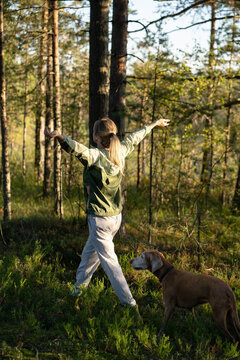 Active lifestyle, body care and moving activity, positive woman hiking in forest accompanied by dog, mindful female spending active weekend outdoors in nature, walking inhaling air with stretched arms