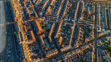 Top down aerial view of coastal town resort streets and buildings at golden hour © Андрей Нелупов