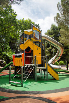 A large yellow steel plastic slide in a children's park on a clear sunny day. Playgrounds, toys, sports activities.