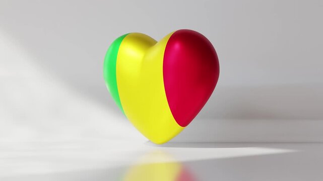 A 3D heart rotates slowly with the colors of Mali. The heart has sections of green, yellow, and red. It moves gracefully against a plain background that highlights its design