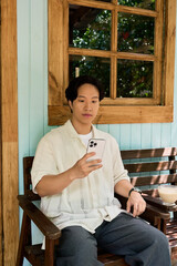 Fototapeta premium Young man enjoying a peaceful moment at a garden cafe in summertime