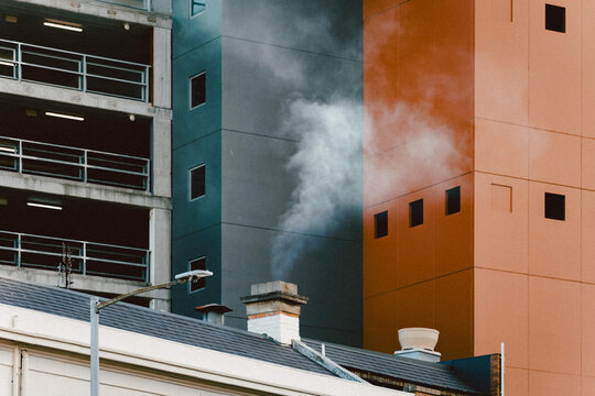Chimney of heritage-style building releasing a plume of smoke