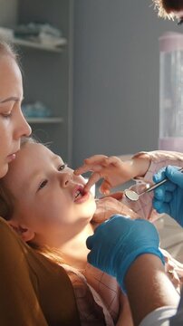 Children dentistry - dentist and little girl with mommy